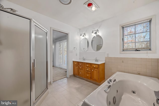 bathroom featuring tile patterned floors, vanity, plus walk in shower, and a wealth of natural light