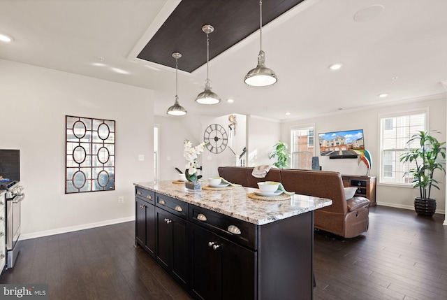 kitchen featuring hanging light fixtures, a kitchen breakfast bar, light stone counters, dark hardwood / wood-style flooring, and a kitchen island