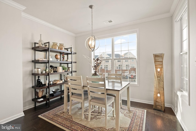 dining space featuring a notable chandelier, ornamental molding, and dark wood-type flooring