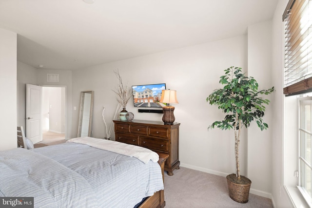 bedroom with multiple windows and light carpet