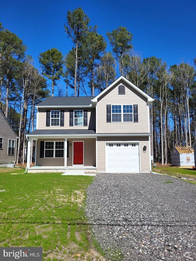 view of front of property with a porch, a garage, and a front lawn