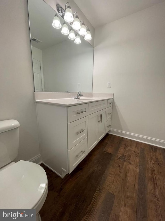 bathroom with vanity, toilet, and wood-type flooring