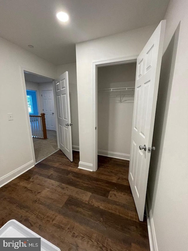 unfurnished bedroom featuring a closet and dark hardwood / wood-style floors