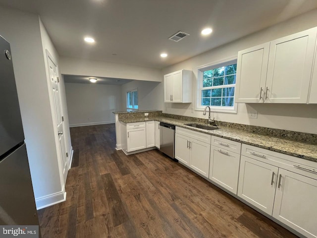 kitchen with kitchen peninsula, appliances with stainless steel finishes, sink, white cabinets, and dark hardwood / wood-style floors