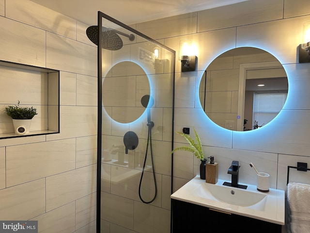 bathroom featuring decorative backsplash, a tile shower, vanity, and tile walls