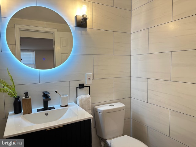 bathroom with vanity, toilet, tile walls, and backsplash