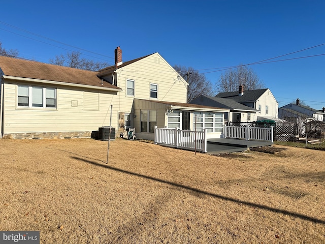 back of house with a lawn, a deck, and central AC