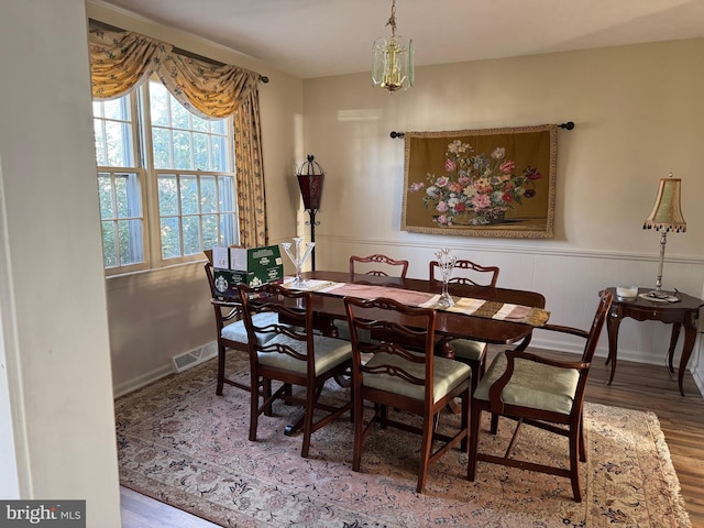 dining area with hardwood / wood-style flooring and a notable chandelier