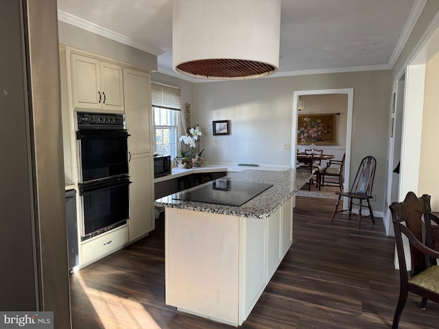 kitchen with dark wood-type flooring, cream cabinetry, black appliances, and ornamental molding