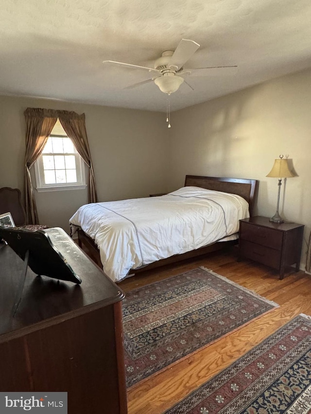 bedroom with wood-type flooring and ceiling fan