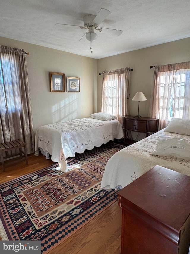 bedroom featuring a textured ceiling, hardwood / wood-style flooring, and ceiling fan