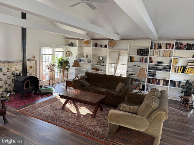 living room featuring vaulted ceiling with beams, dark hardwood / wood-style floors, a wood stove, and ceiling fan