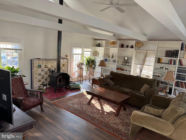 living room featuring hardwood / wood-style floors, ceiling fan, a wood stove, and a wealth of natural light