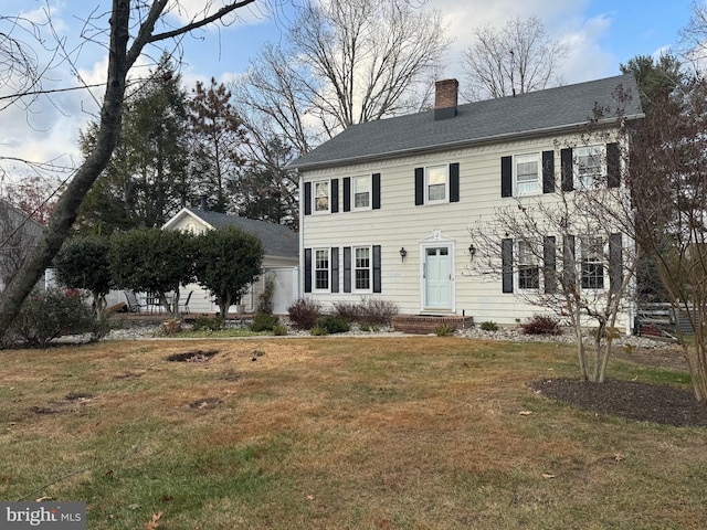 colonial-style house featuring a front lawn