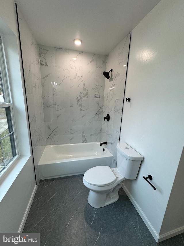 bathroom with tiled shower / bath combo and toilet