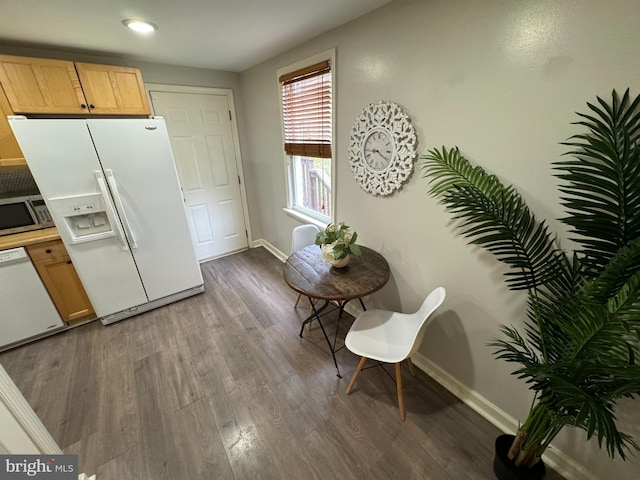 kitchen with light brown cabinets, white appliances, and dark wood-type flooring