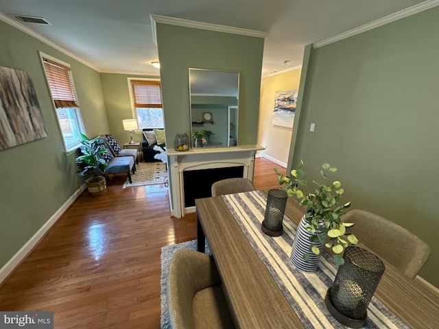 dining area with hardwood / wood-style flooring and ornamental molding