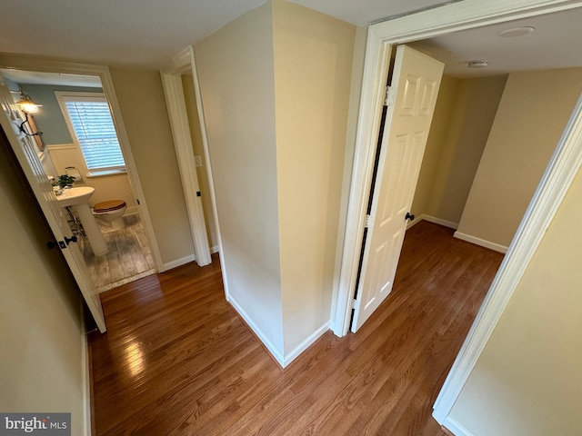 corridor with hardwood / wood-style flooring