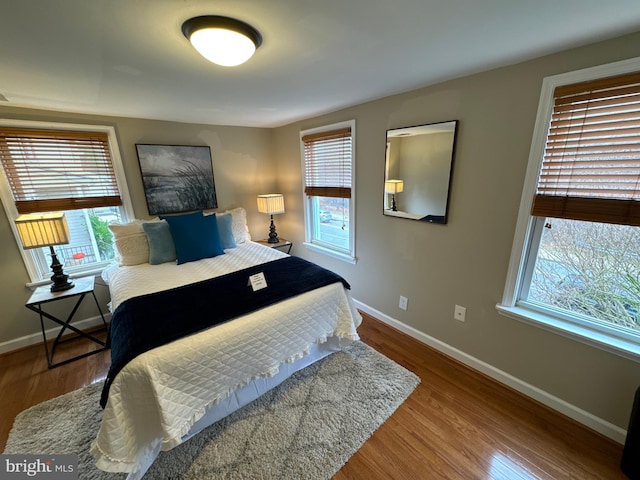 bedroom featuring hardwood / wood-style flooring and multiple windows