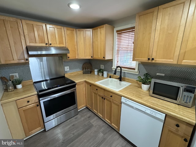 kitchen featuring backsplash, dishwasher, stainless steel range with electric stovetop, and sink