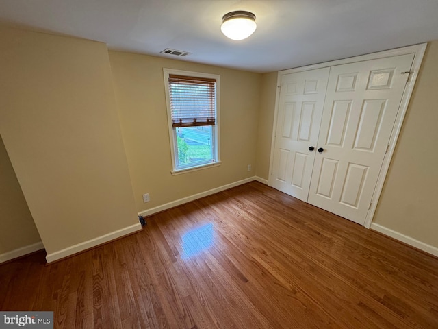 unfurnished bedroom featuring hardwood / wood-style flooring and a closet