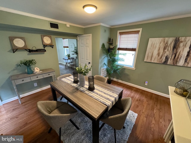 dining area with dark hardwood / wood-style floors and crown molding