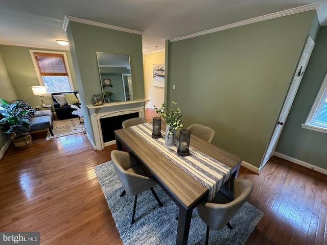 dining area with a healthy amount of sunlight, ornamental molding, and dark wood-type flooring