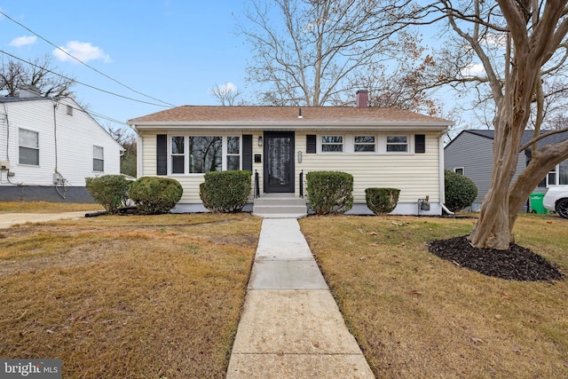 bungalow-style home with a front lawn