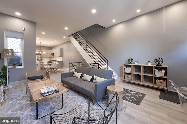 living room with an inviting chandelier and light hardwood / wood-style floors