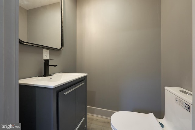 bathroom featuring vanity, toilet, and wood-type flooring