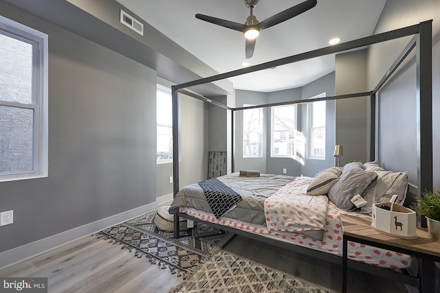 bedroom featuring hardwood / wood-style flooring and multiple windows