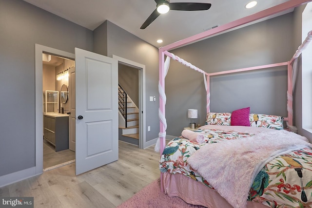 bedroom featuring ceiling fan, ensuite bathroom, and light wood-type flooring