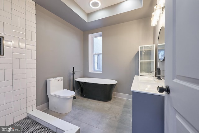 bathroom featuring vanity, a bathtub, a tray ceiling, and toilet