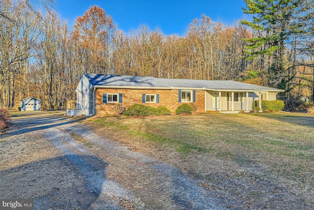 ranch-style house with a porch, a garage, a front lawn, and an outdoor structure