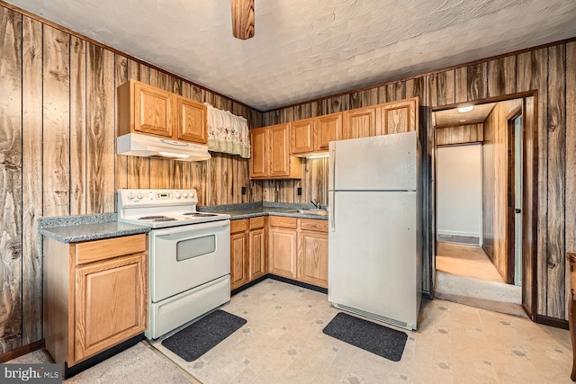 kitchen featuring wooden walls, sink, and white appliances