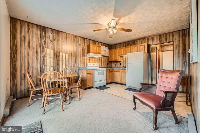 kitchen featuring white appliances, ceiling fan, and wood walls