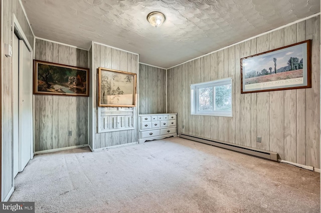 unfurnished bedroom featuring light colored carpet, wooden walls, and a baseboard radiator