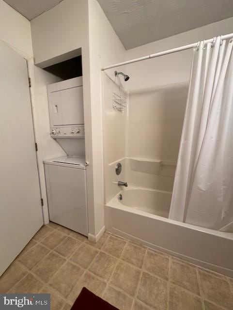 bathroom featuring stacked washer and dryer and shower / bathtub combination with curtain