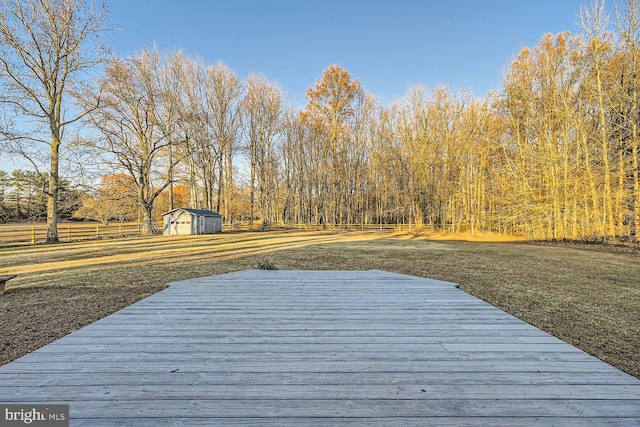 deck with a storage shed and a yard