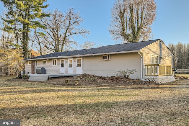 rear view of property with a lawn and a deck