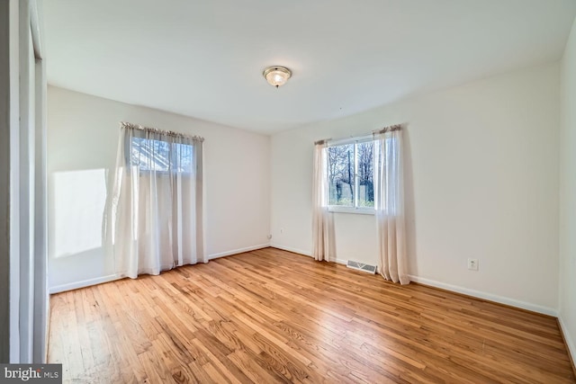 spare room with light hardwood / wood-style floors and a wealth of natural light