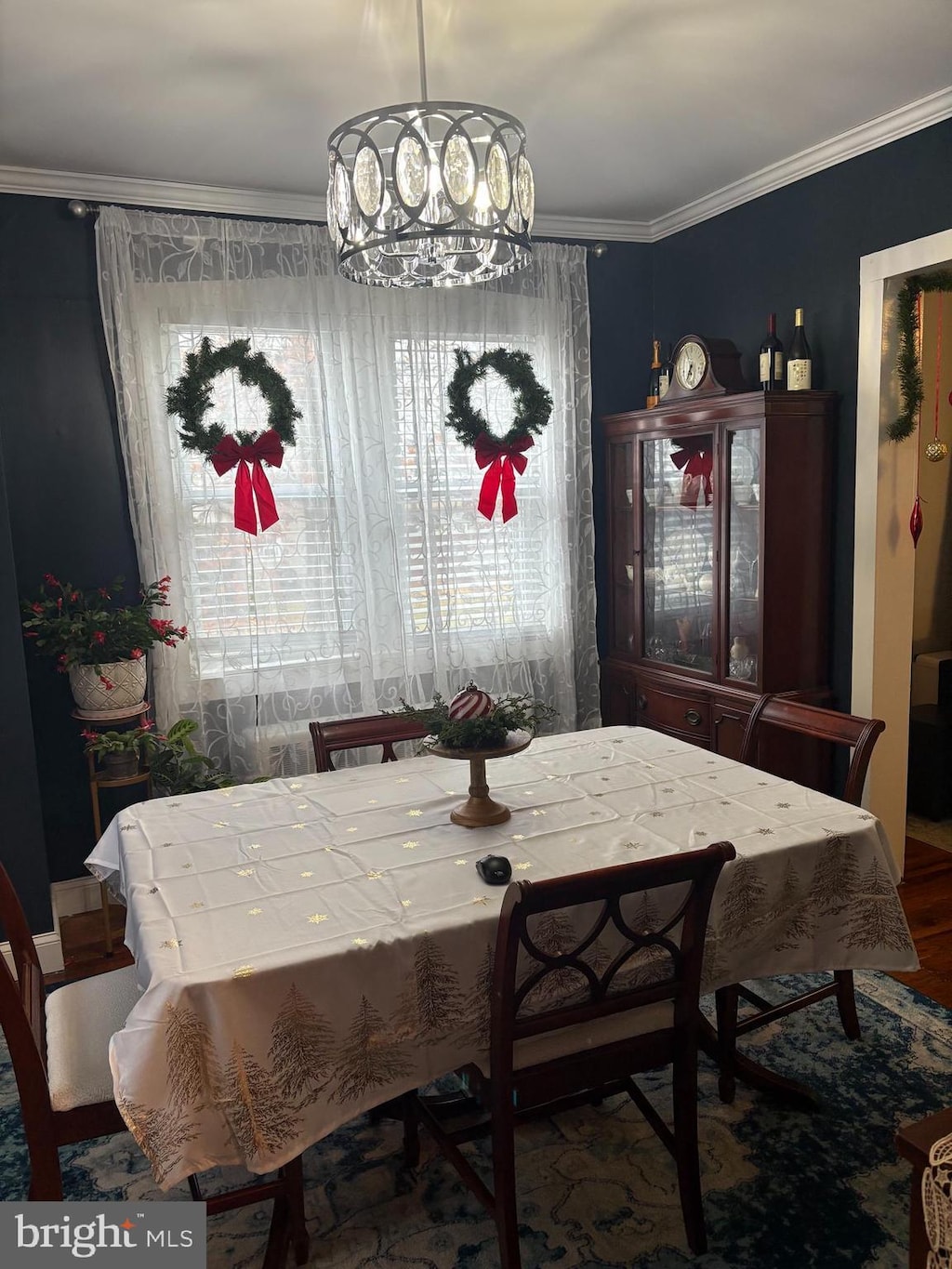 dining room featuring hardwood / wood-style flooring, crown molding, and an inviting chandelier