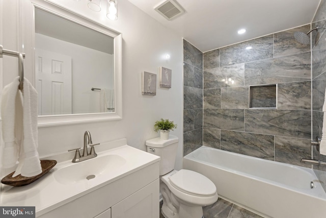 full bathroom featuring toilet, vanity, and tiled shower / bath