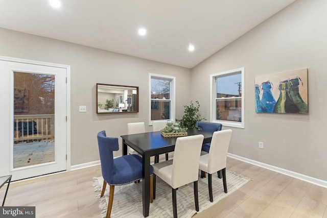 dining space with vaulted ceiling and light hardwood / wood-style flooring