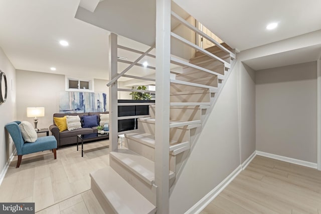 staircase featuring hardwood / wood-style floors and a fireplace