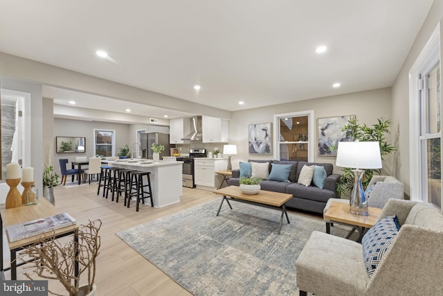 living room featuring sink and light hardwood / wood-style flooring