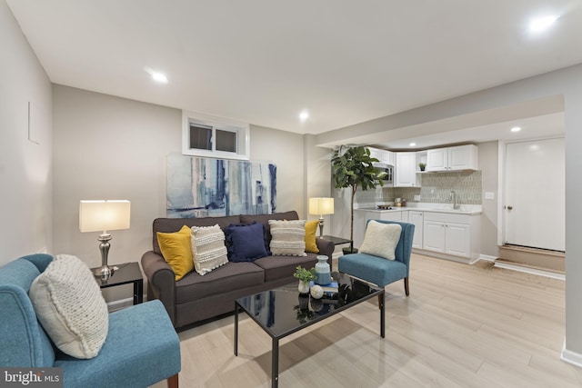 living room featuring sink and light hardwood / wood-style flooring