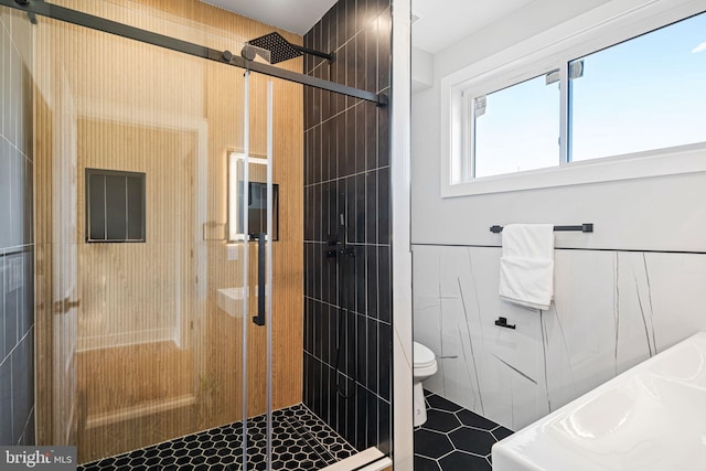 bathroom featuring toilet, walk in shower, and tile walls