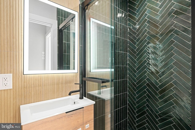 bathroom with wooden walls, vanity, and walk in shower