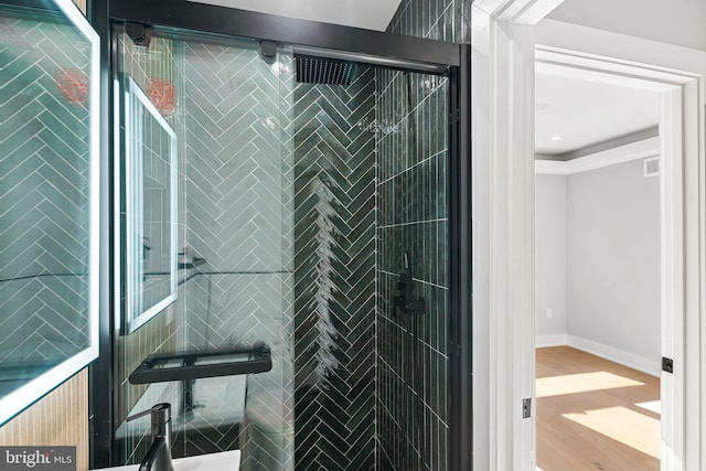 interior details with wood-type flooring and a shower with door